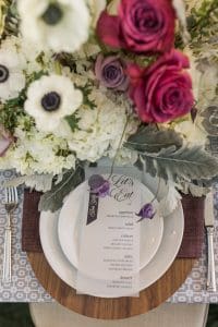 flowers next to plate at wedding