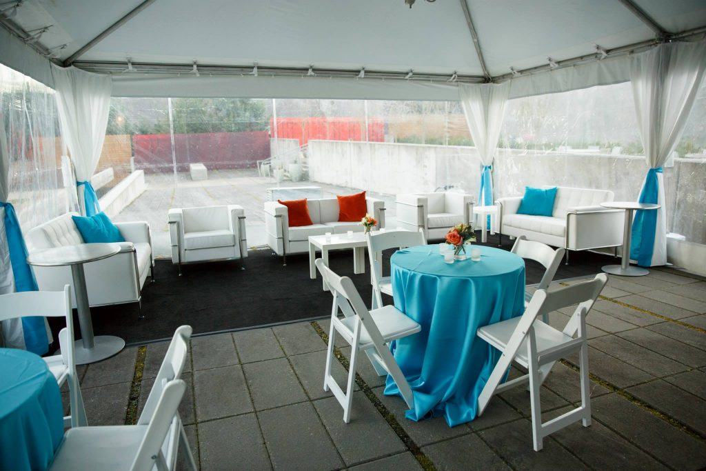 Tent with tables, blue linens and white chairs